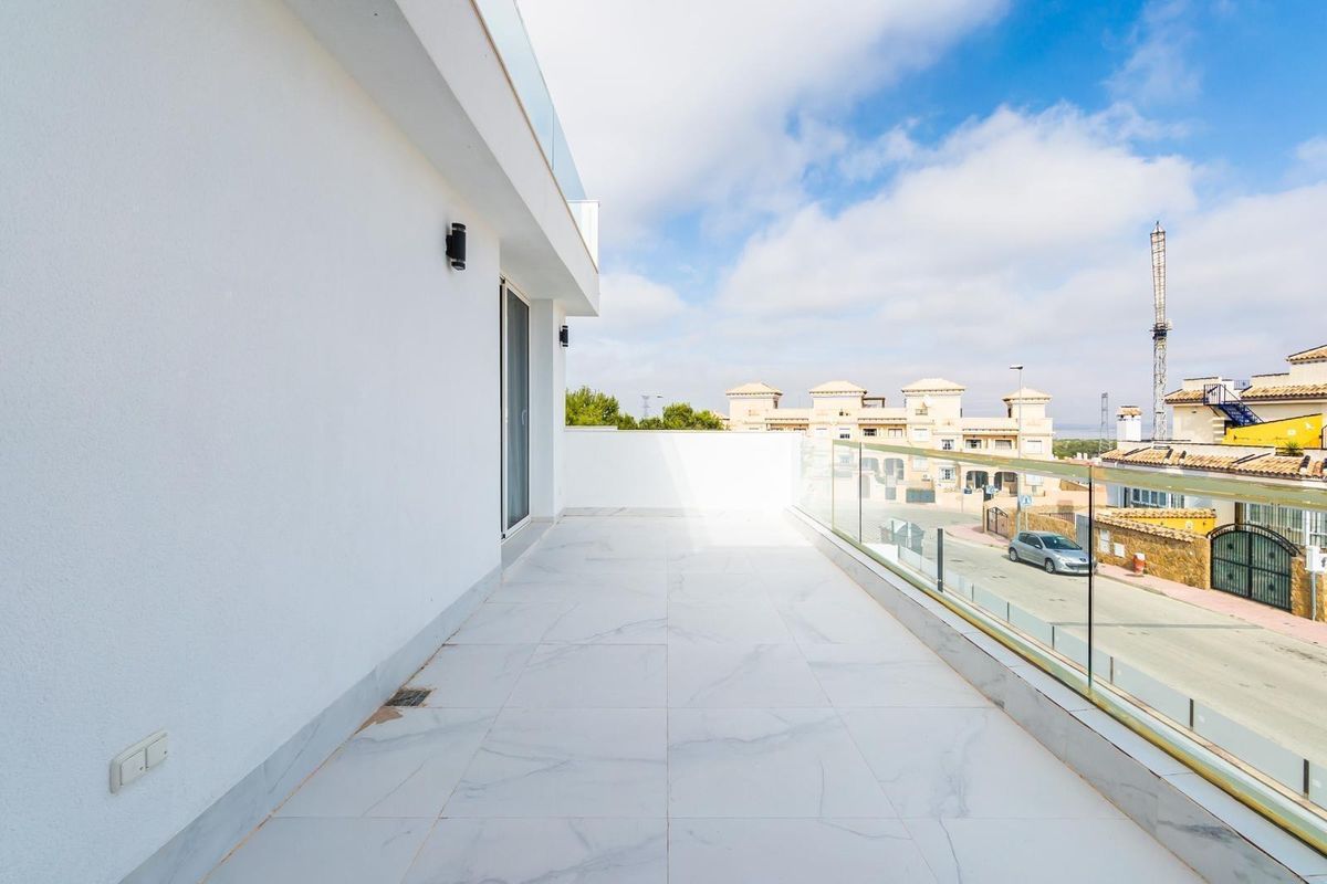 Bright, modern terrace with glass railing overlooking the street in Orihuela Costa.