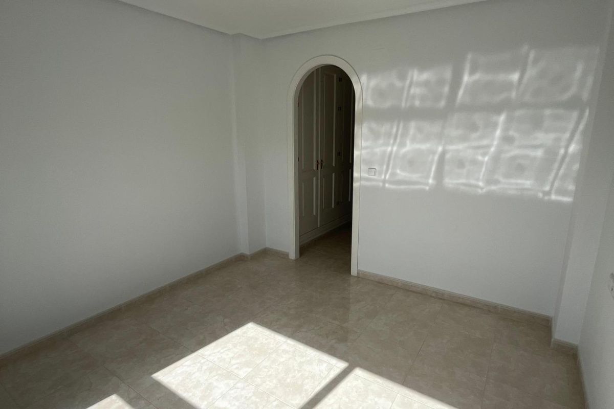 Heldere slaapkamer die zonlicht opvangt en ruimte biedt voor een gezellige inrichting in een appartement op de begane grond in Orihuela Costa.