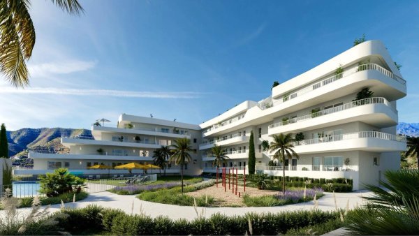 Buitenzicht op een modern appartementencomplex in Fuengirola, met palmbomen en een speeltuin.