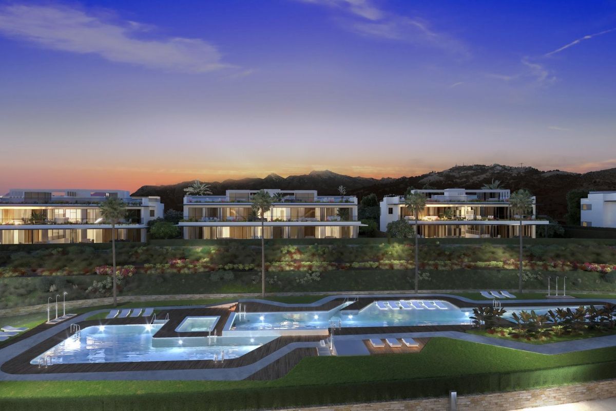 Avondzicht op het luxe bungalowcomplex in Marbella, prachtig verlicht met een adembenemend zwembadgebied.