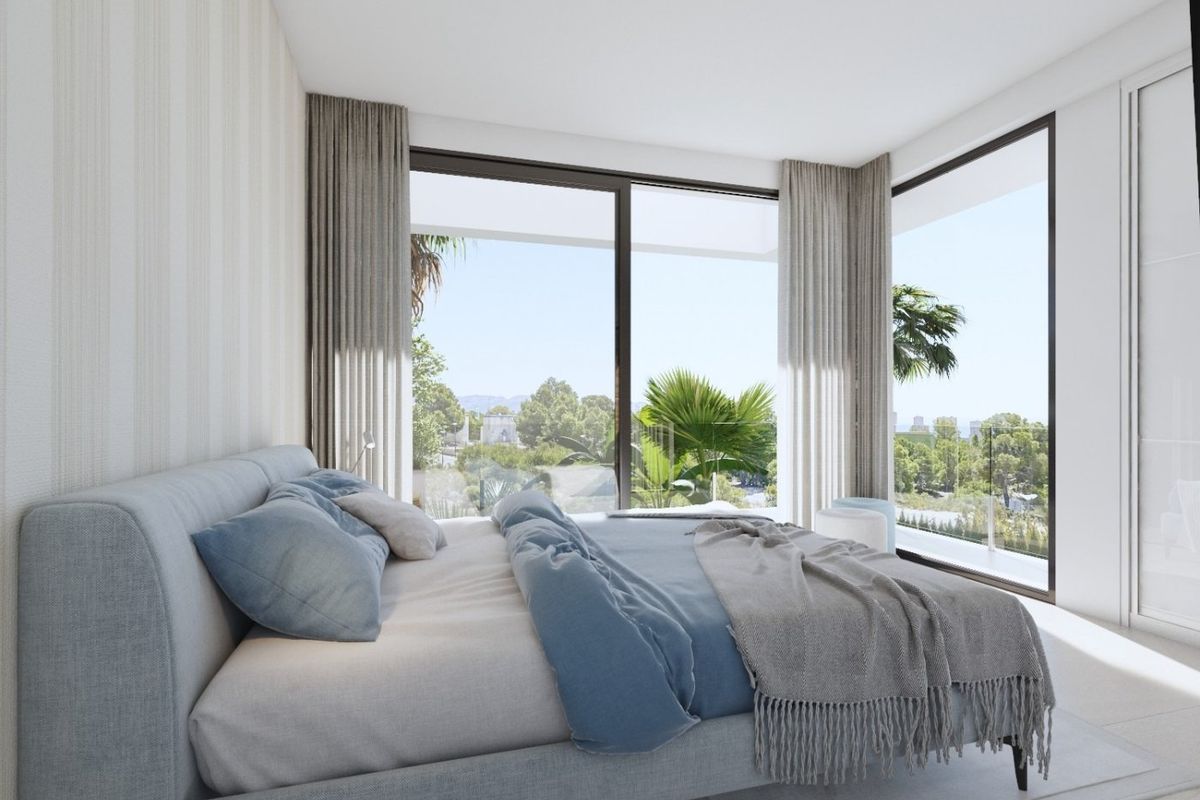 Ruime slaapkamer met grote ramen in de villa in Finestrat, met uitzicht op het serene landschap en natuurlijk licht.