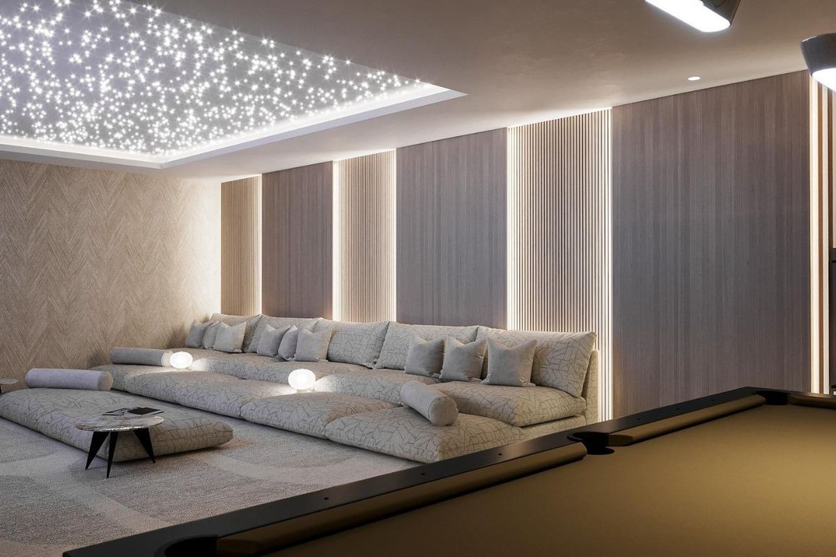 Gezellige filmavond setting met zachte zithoek en biljarttafel, deel van een luxe villa in Marbella.