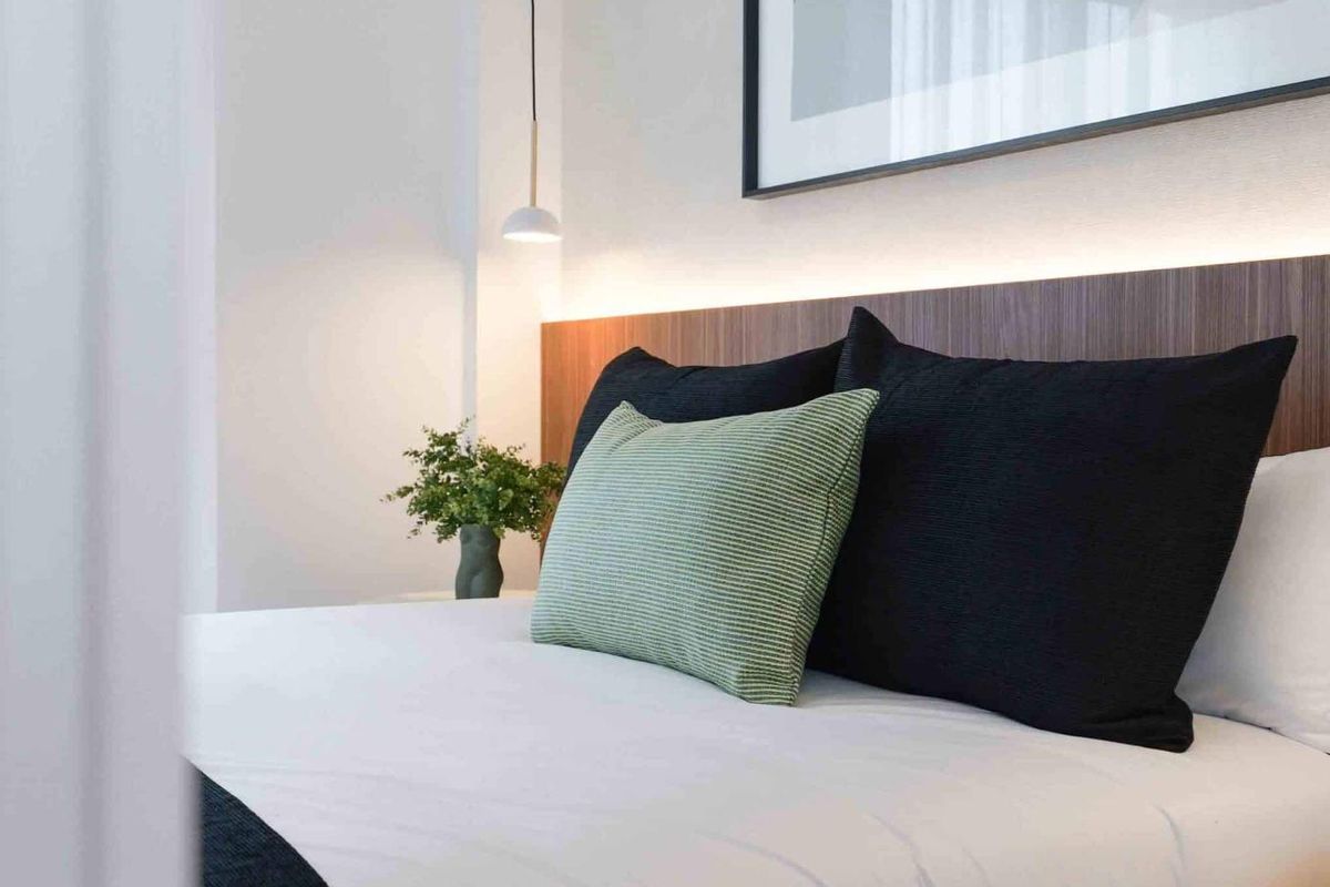 Gezellige slaapkamerhoek met een chique bed en moderne kunst, gelegen in Rojales, Costa Blanca Zuid, Spanje.