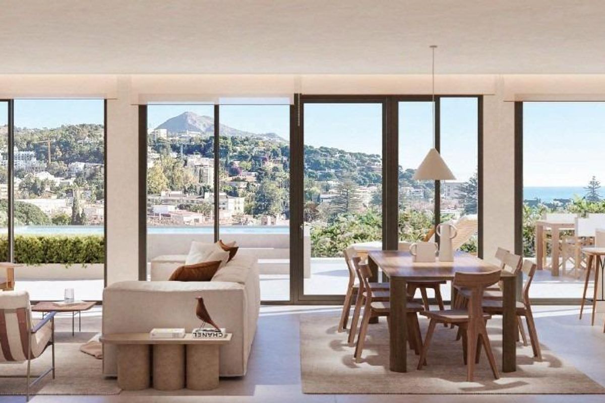 Heldere open woon- en eetruimte met grote ramen en uitzicht op zee in Málaga.