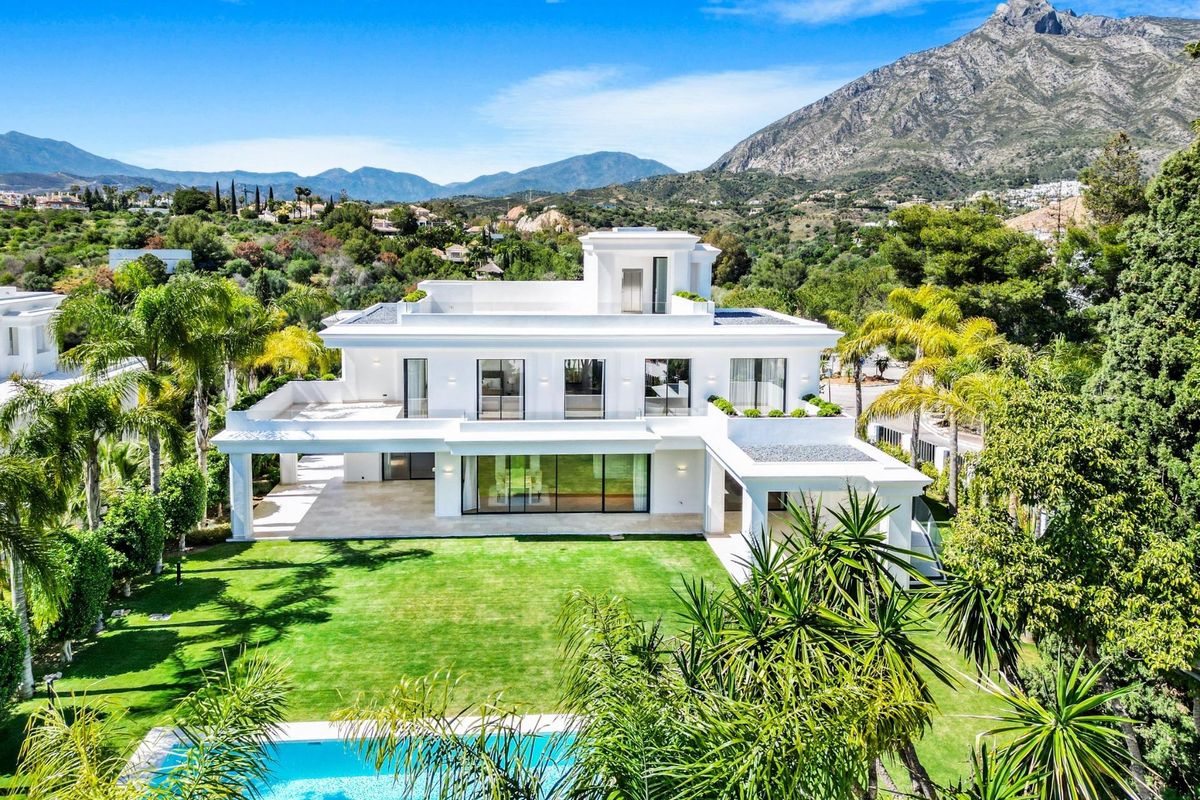 Luchtfoto van een prachtige villa in Marbella omgeven door groen en bergen.