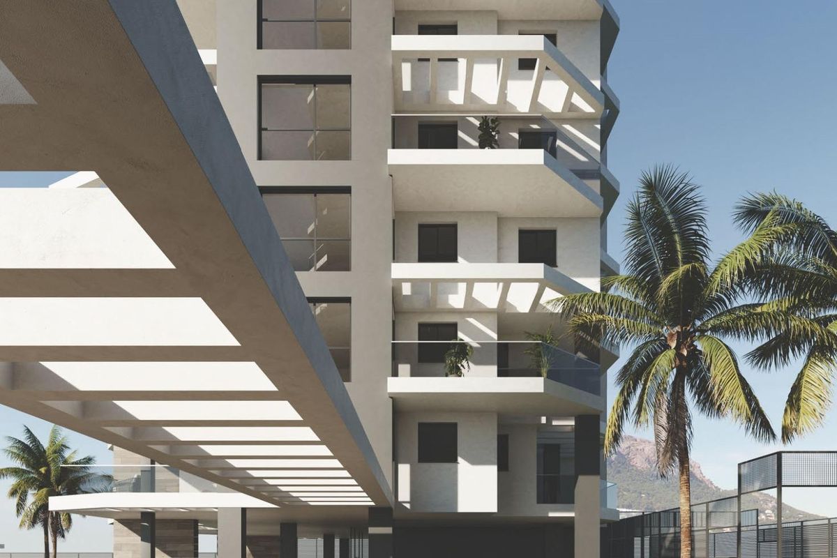 Ingang van modern appartementgebouw met aangelegde tuinen naar het zwembad in Calpe.