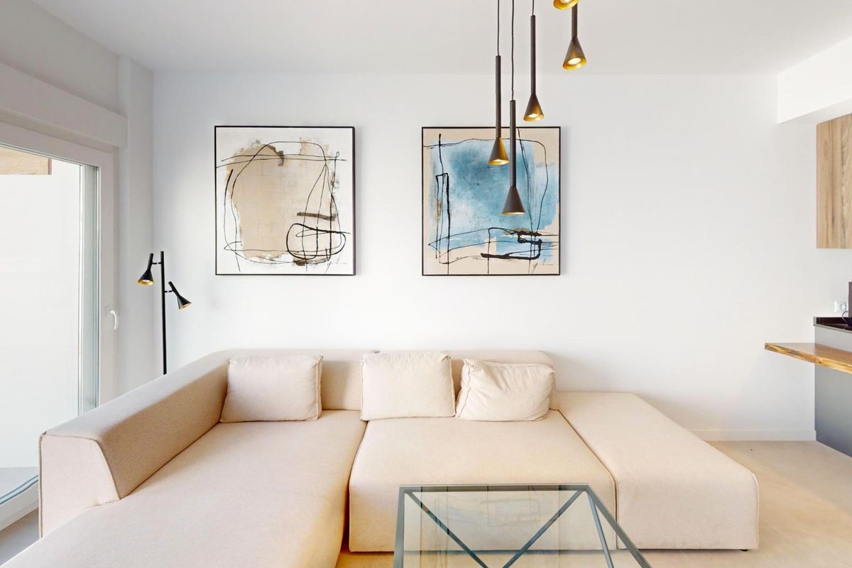 Gezellige woonkamer van een appartement op de begane grond in Pilar de La Horadada met moderne kunst en een comfortabele bank.