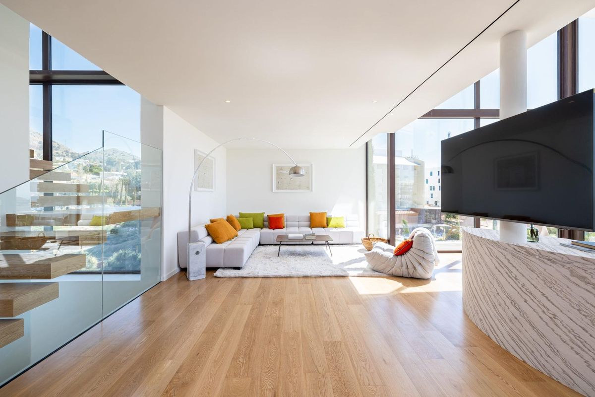Woonkamer in een 4-slaapkamer herenhuis in fuengirola met een zwevende trap en moderne inrichting.