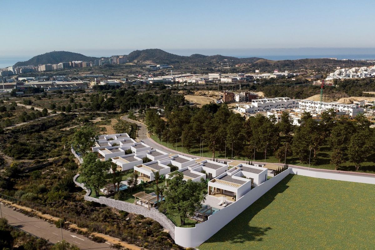 Luchtfoto van een nieuwe villawijk in Finestrat, Costa Blanca, omringd door heuvels en groen.