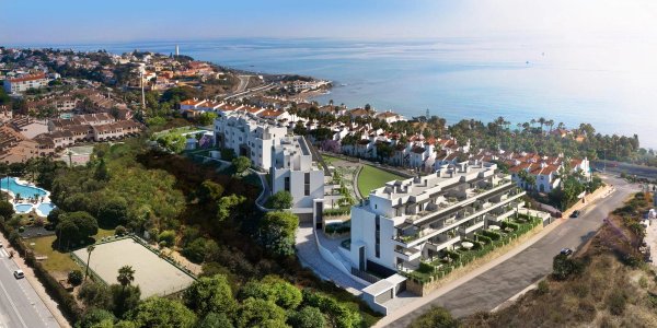 Luchtfoto van een modern appartementencomplex nabij het strand in Mijas, Costa del Sol, met weelderige tuinen.