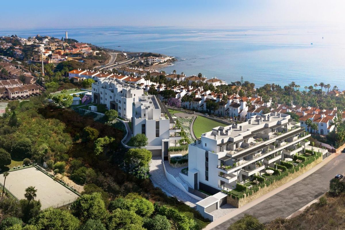 Luchtfoto van een modern appartementencomplex nabij het strand in Mijas, Costa del Sol, met weelderige tuinen.