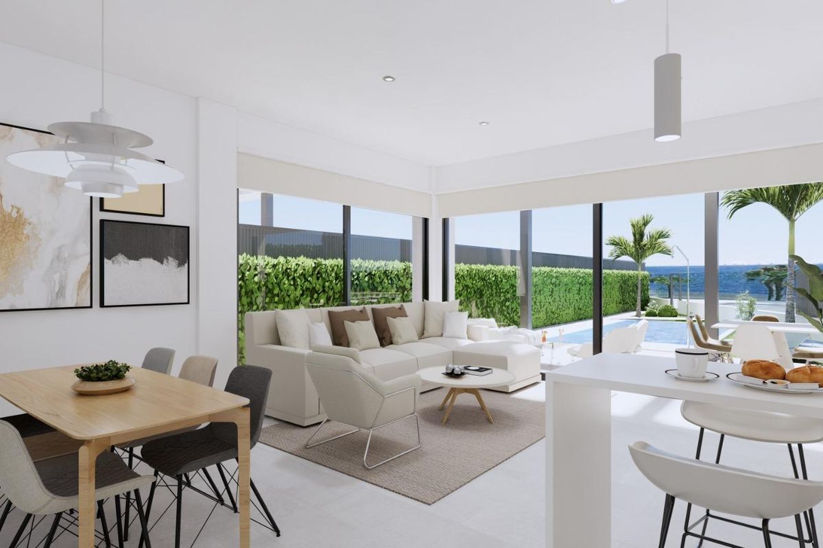 Lichte woonkamer met moderne meubels, eetruimte en uitzicht op het zwembad in een villa in Los Alcazares.
