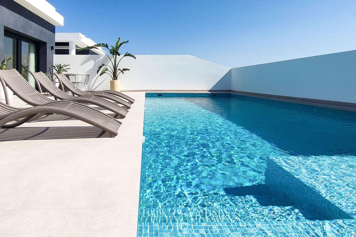 Elegante ligstoelen naast het zwembad van een moderne villa met 5 slaapkamers in Rojales, perfect voor zonnen.