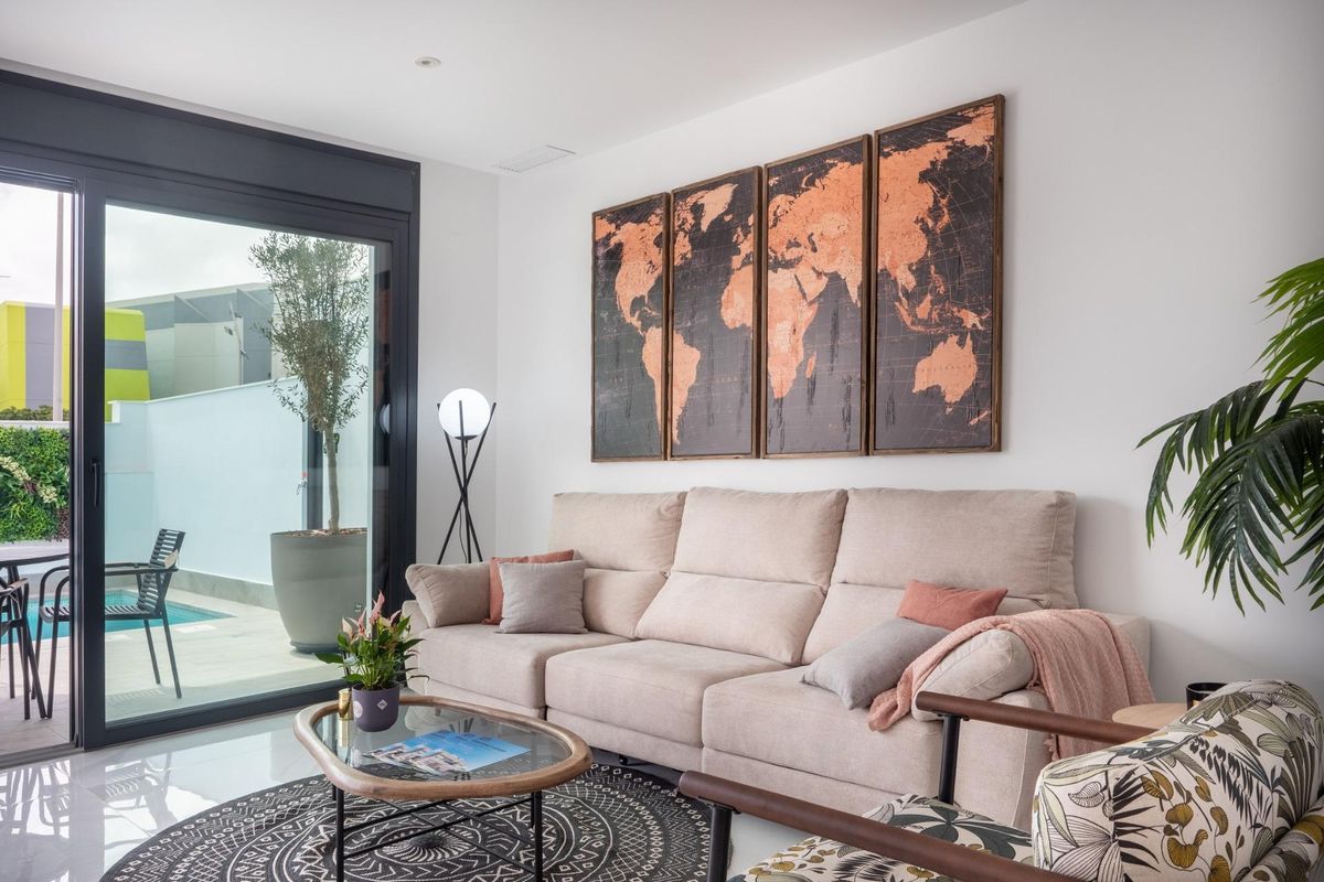 Lichte woonkamer met grote glazen deuren naar een terras en tuin in een villa in San Pedro del Pinatar.