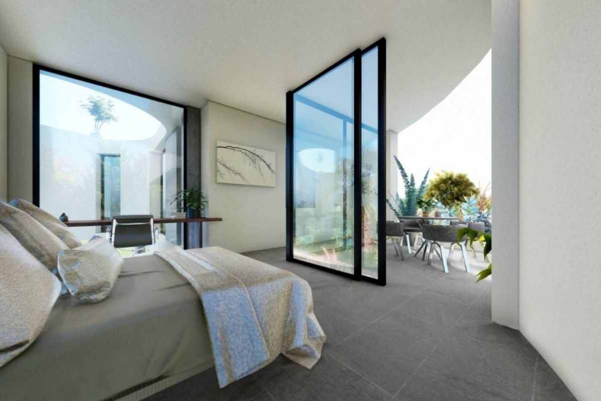 Ruime slaapkamer in de villa in Orihuela Costa, met grote glazen deuren naar de tuin.