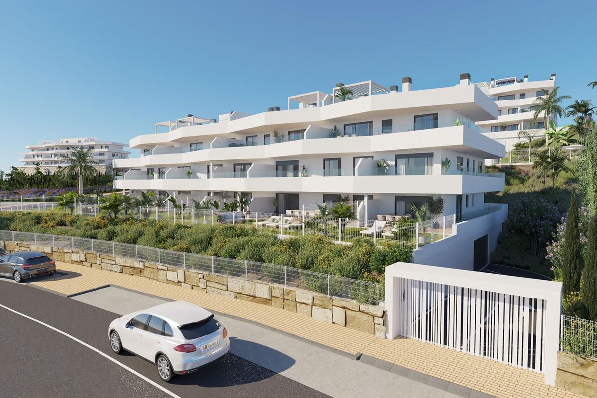 Buitenkant van het penthousecomplex met aangelegde tuinen en moderne architectuur in Estepona.