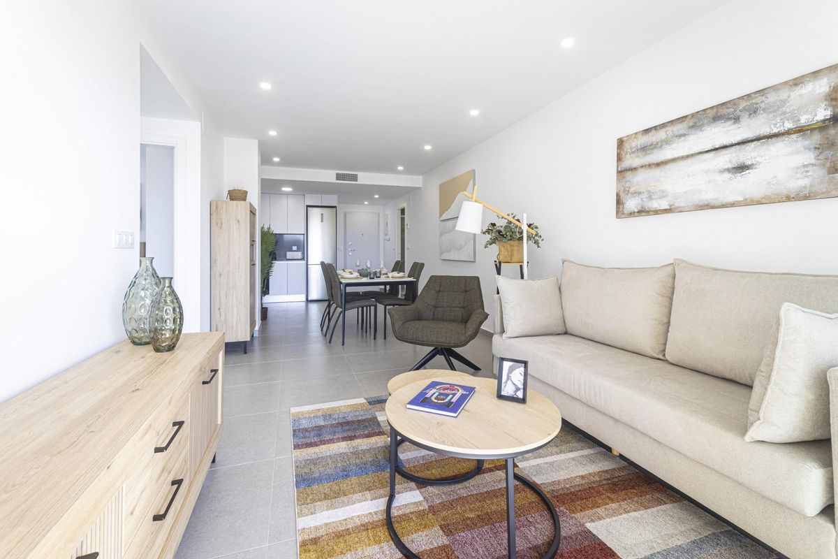Stijlvolle woonkamer met een bank, salontafel en eetruimte, helder en luchtig in een appartement in La Manga.
