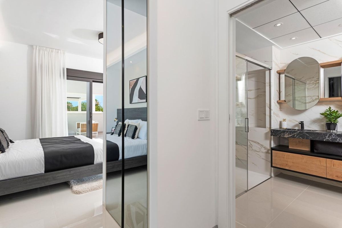 Chic interieurontwerp dat een uitzicht toont tussen de slaapkamer en badkamer in een villa in Ciudad Quesada.