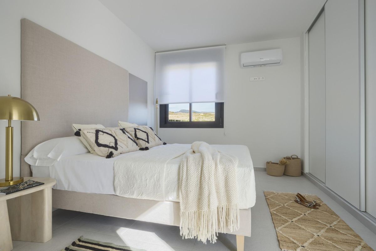 Ruime slaapkamer met een tweepersoonsbed, natuurlijk licht en moderne decoratie in een 3-slaapkamer townhouse in Baños y Mendigo.