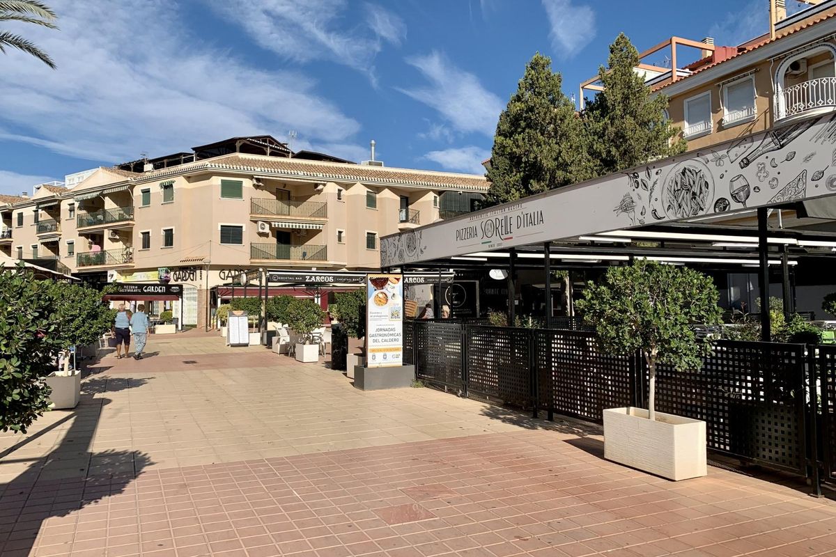 Buiten zitgedeelte van een Italiaans restaurant, omringd door winkels in Los Alcazares.