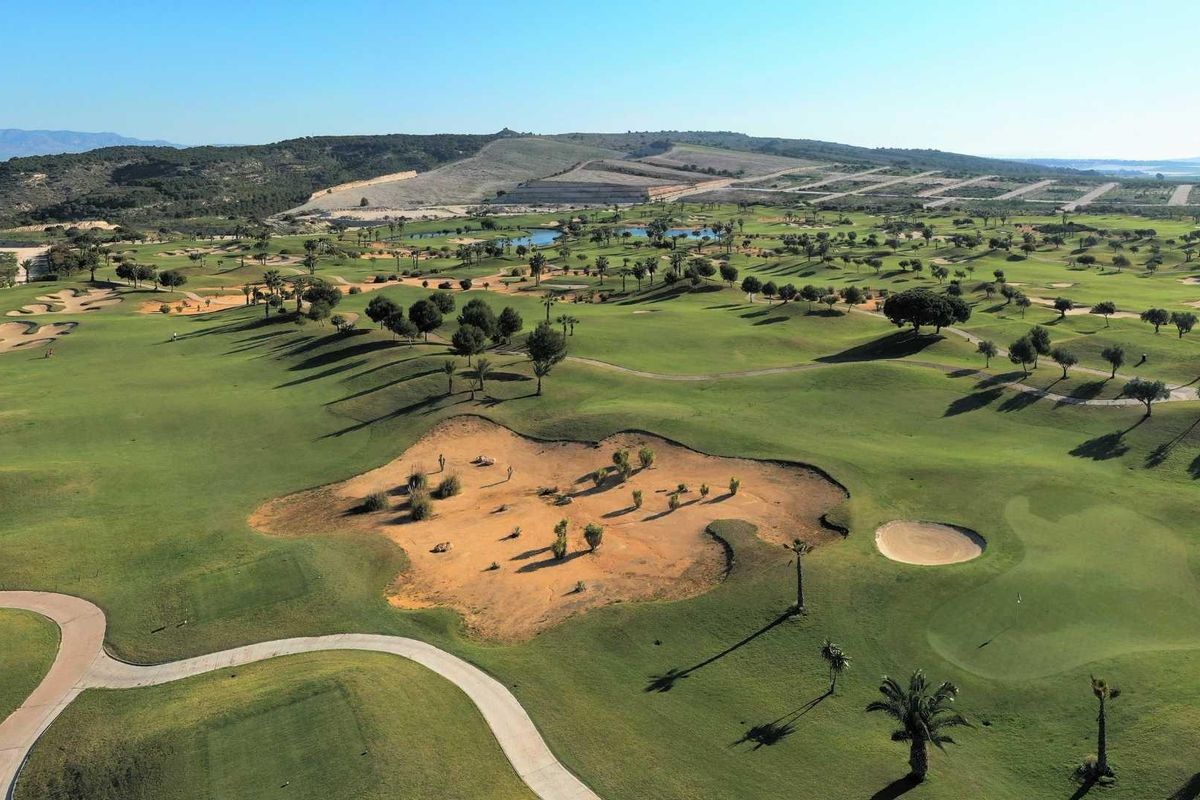 Uitgestrekt groen landschap van een golfbaan in Orihuela, met unieke zandgebieden.