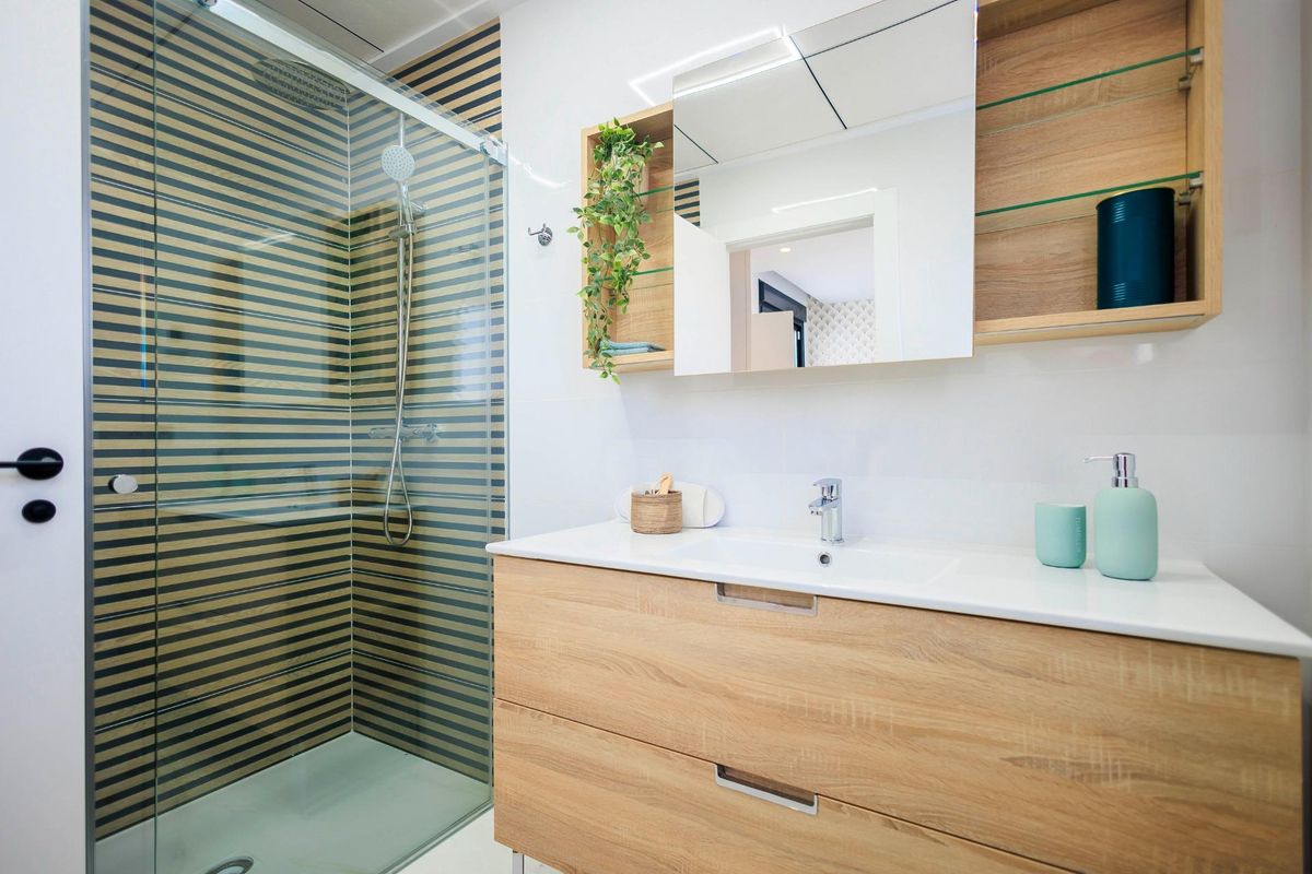 Stijlvolle douche in de badkamer van de villa met houten panelen in Pilar de La Horadada.