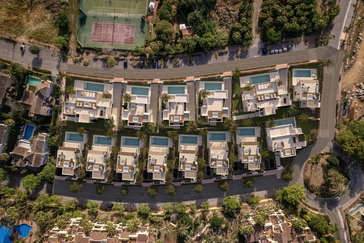 Overzicht van een luxe villacomplex in Estepona, met aangelegde tuinen en zwembaden.