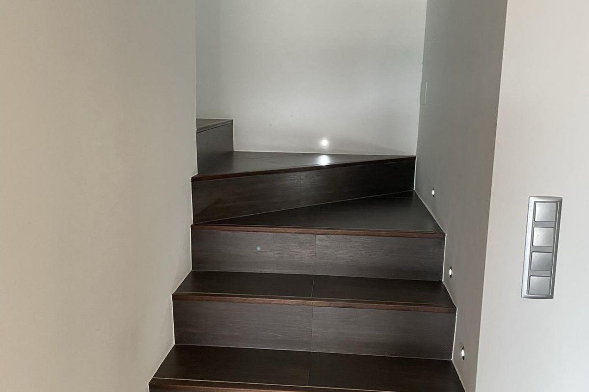 Stijlvolle trap met donkere houten treden die naar de bovenverdiepingen van een villa leidt in Moraira Teulada.