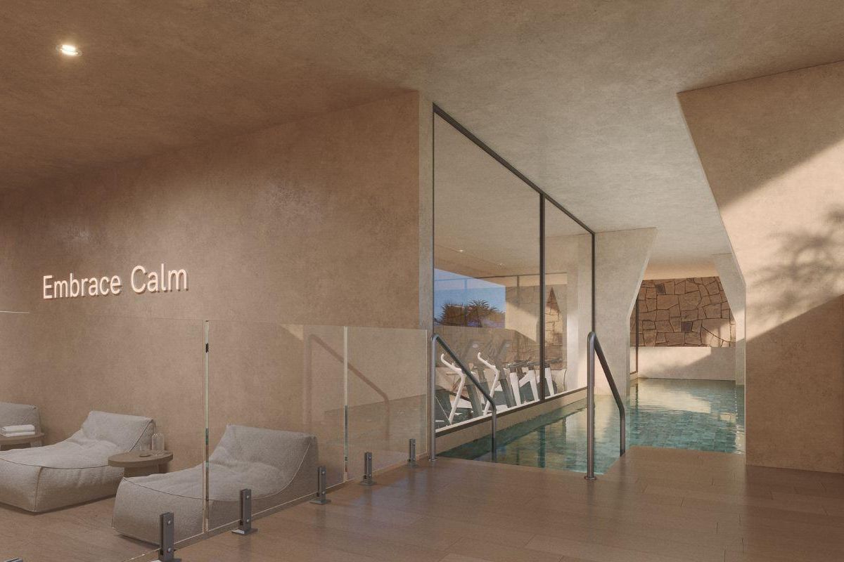 Luxe binnenzwembad met ligstoelen, bevorderlijk voor ontspanning in een appartementengebouw in Torremolinos.