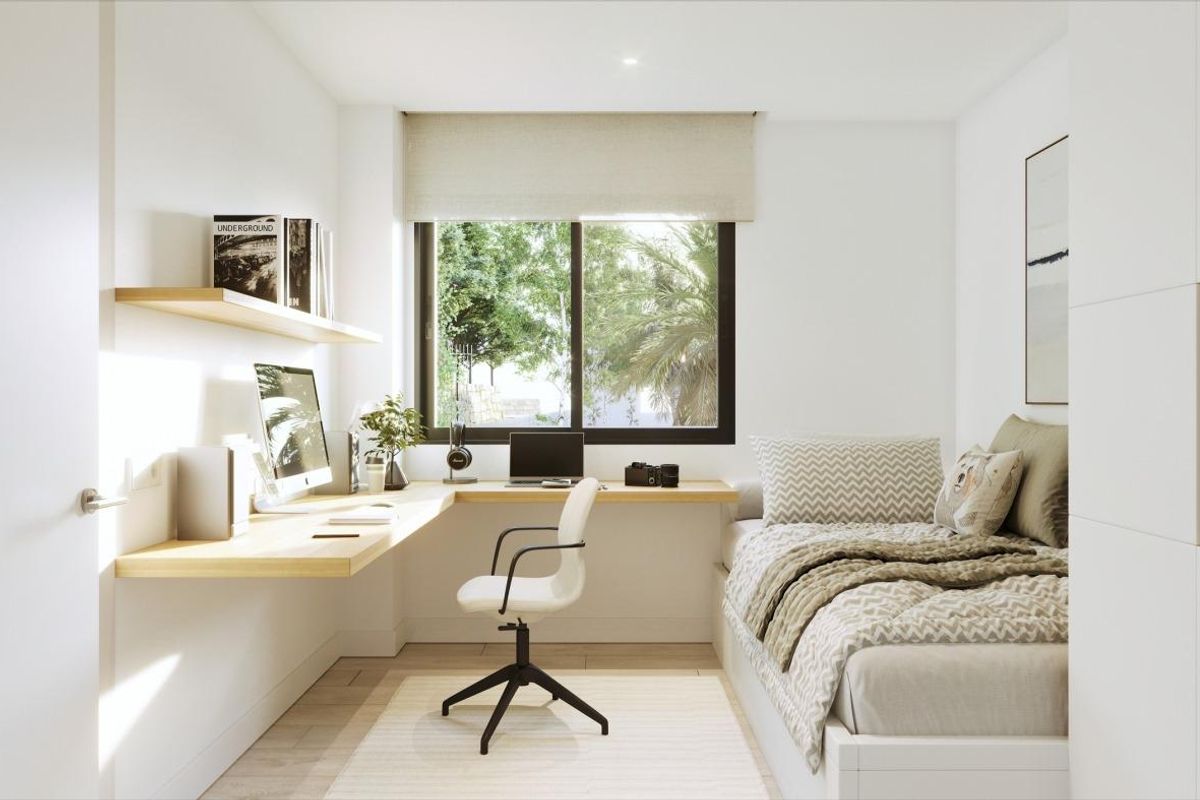 Heldere slaapkamer in een 3-slaapkamer appartement in Casares, met een studiehoek en een groot raam met tuinzicht.