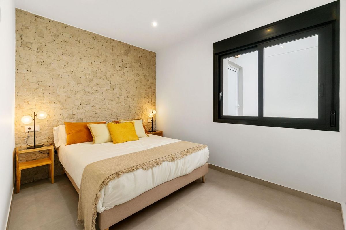 Uitnodigende slaapkamer met warme kleuren en veel natuurlijk licht, gelegen in een townhouse in San Pedro del Pinatar, Spanje.