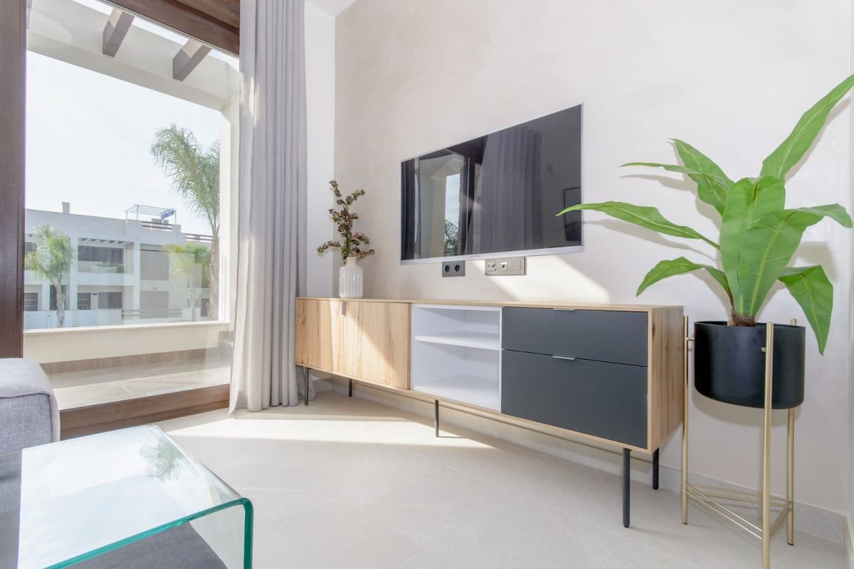 Woonkamer met strakke kast en plant bij de balkondeuren in een 3-slaapkamer bungalow in Torrevieja, Costa Blanca.