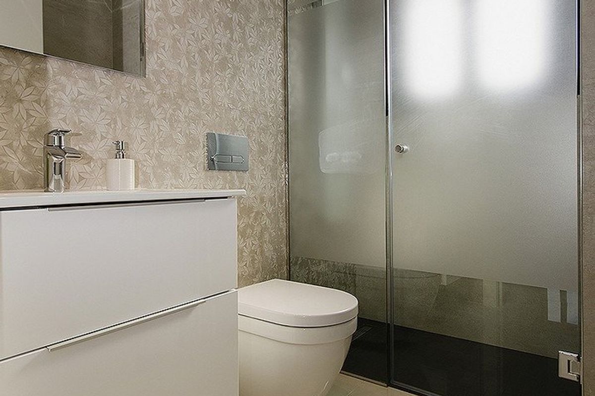 Stijlvolle badkamer met elegante armaturen en een glazen douche, onderdeel van een villa in Orihuela Costa, Spanje.