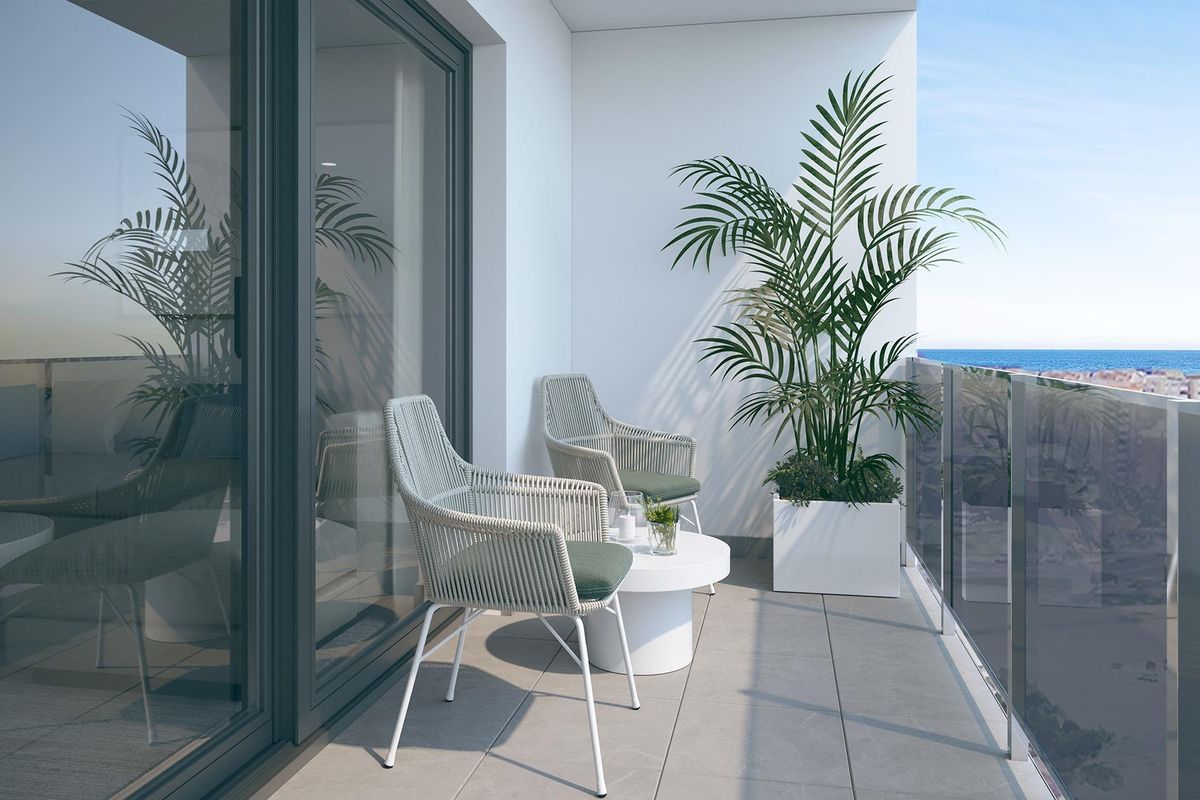 Gezellig balkon met twee stoelen en planten, met uitzicht op de kustlijn van Alicante.