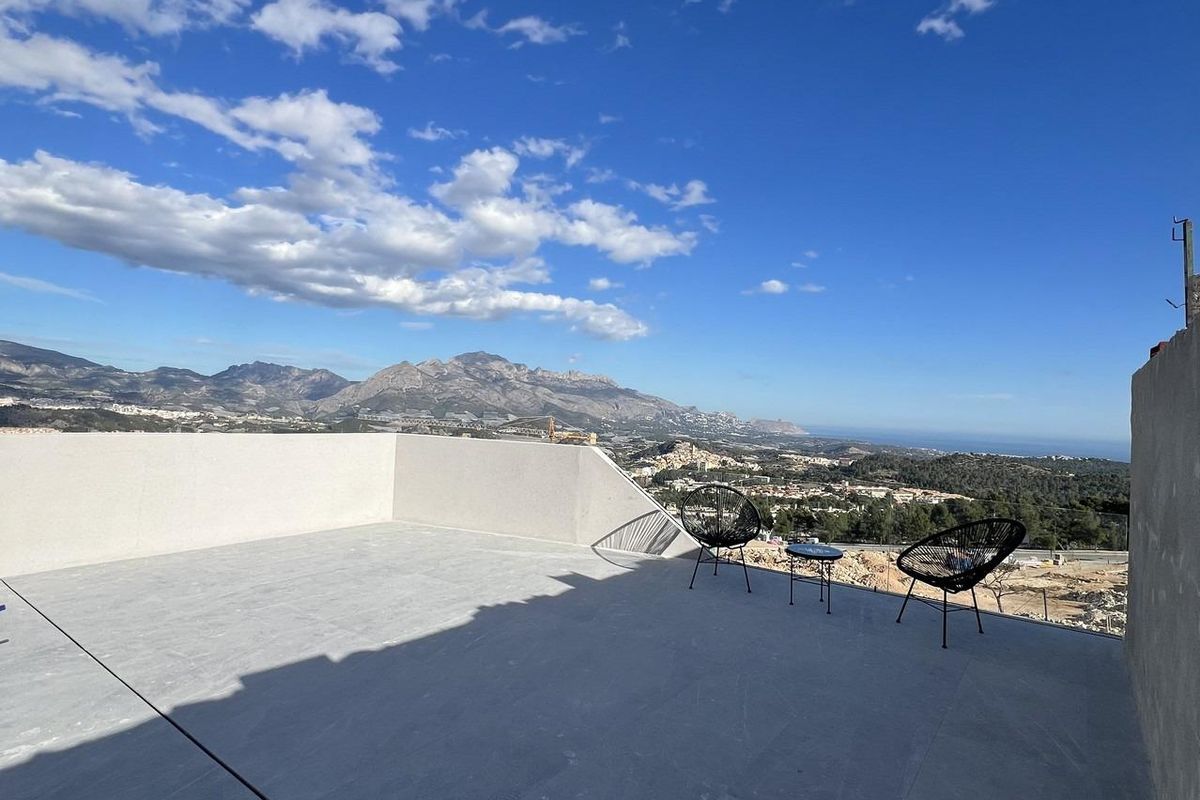 Ruime terras in een townhouse in Polop met twee stoelen, biedt een spectaculair uitzicht op de bergen.