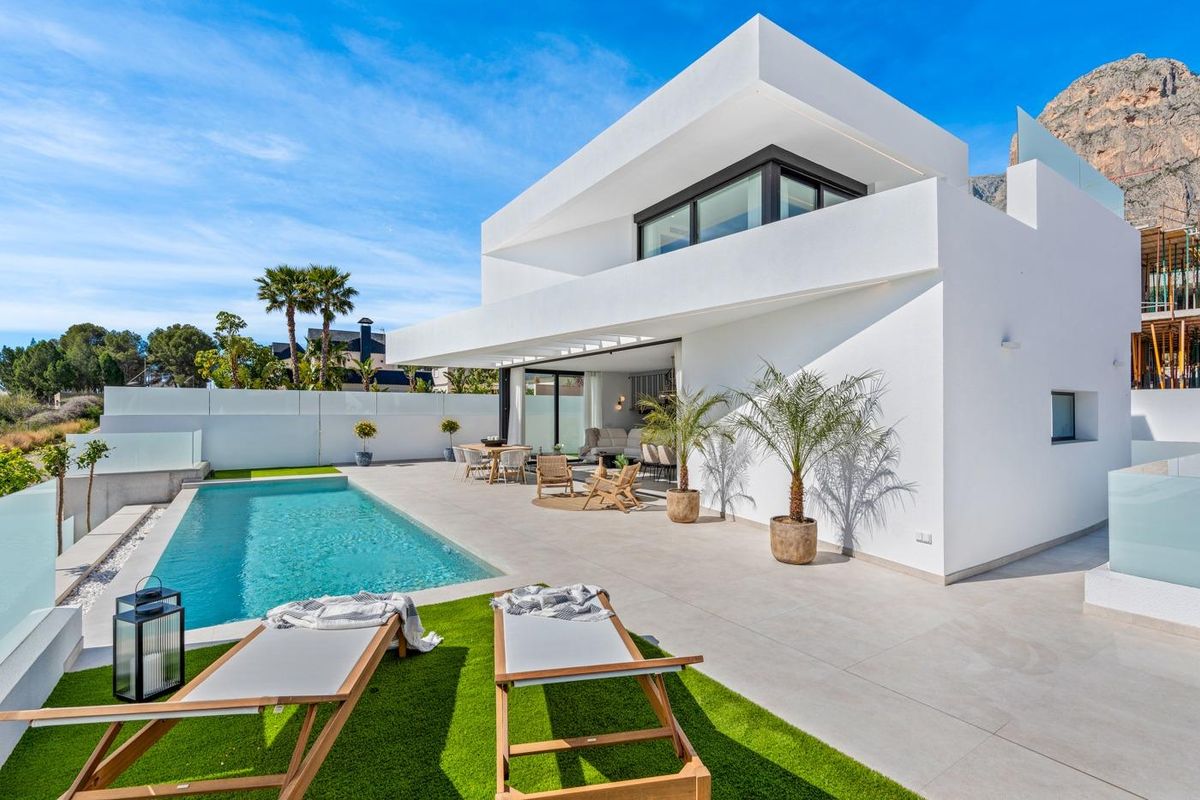 Zonnige buitenkant van een 3-slaapkamer villa in Polop, met zwembad en palmbomen.