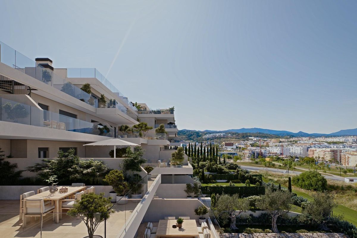 Buitenzicht op het moderne penthouse gebouw in Estepona, met stijlvolle architectuur en groenvoorzieningen.