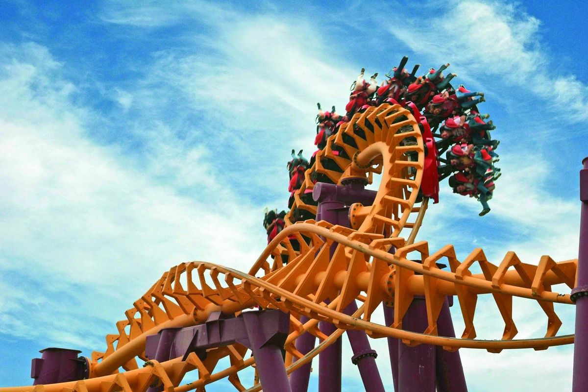 Spannende achtbaanrit in een pretpark, met rijders vol enthousiasme.