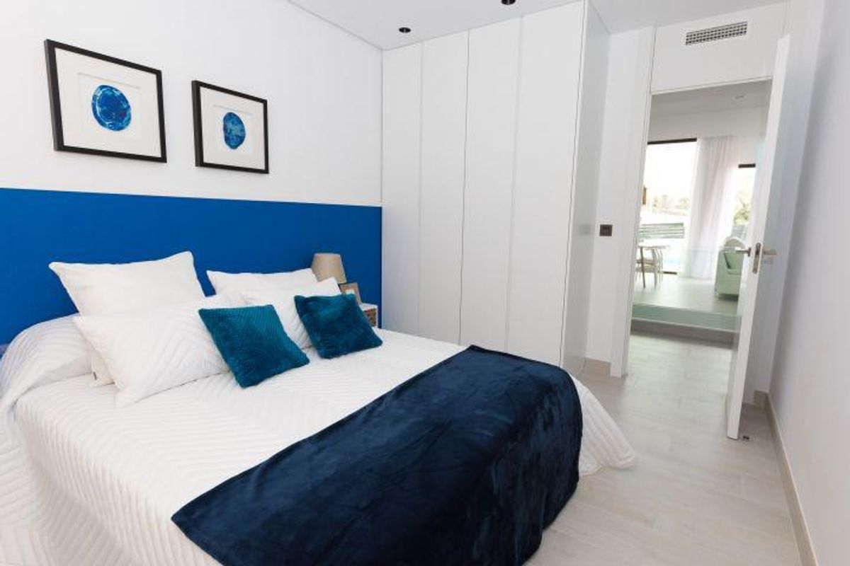 Moderne slaapkamer in blauw en wit met kunstwerk in villa in Finestrat