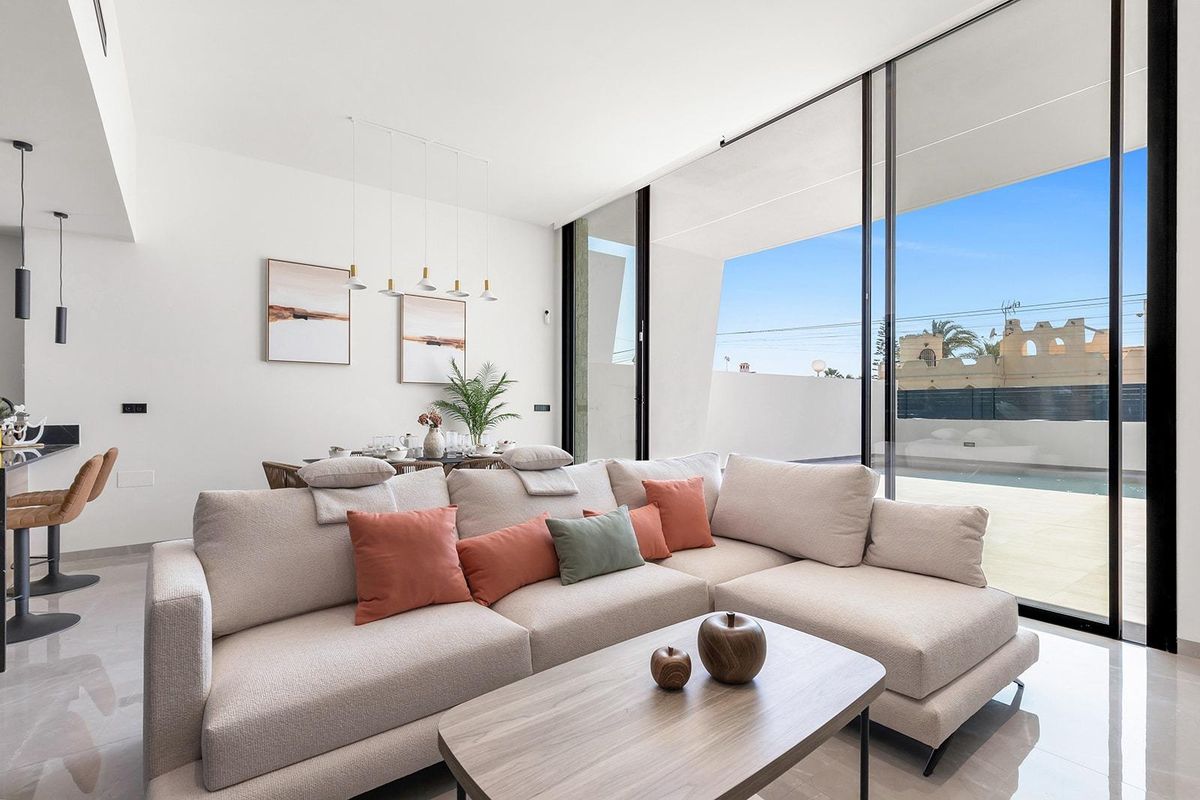 Open leefruimte met grote ramen in een villa, met een mix van binnencomfort en uitzicht op het zwembad.