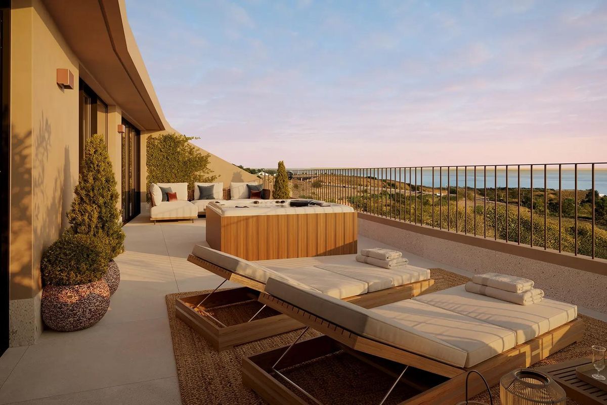 Stijlvol terras van een penthouse in Fuengirola, met een hottub en ligbedden met uitzicht op de zee.