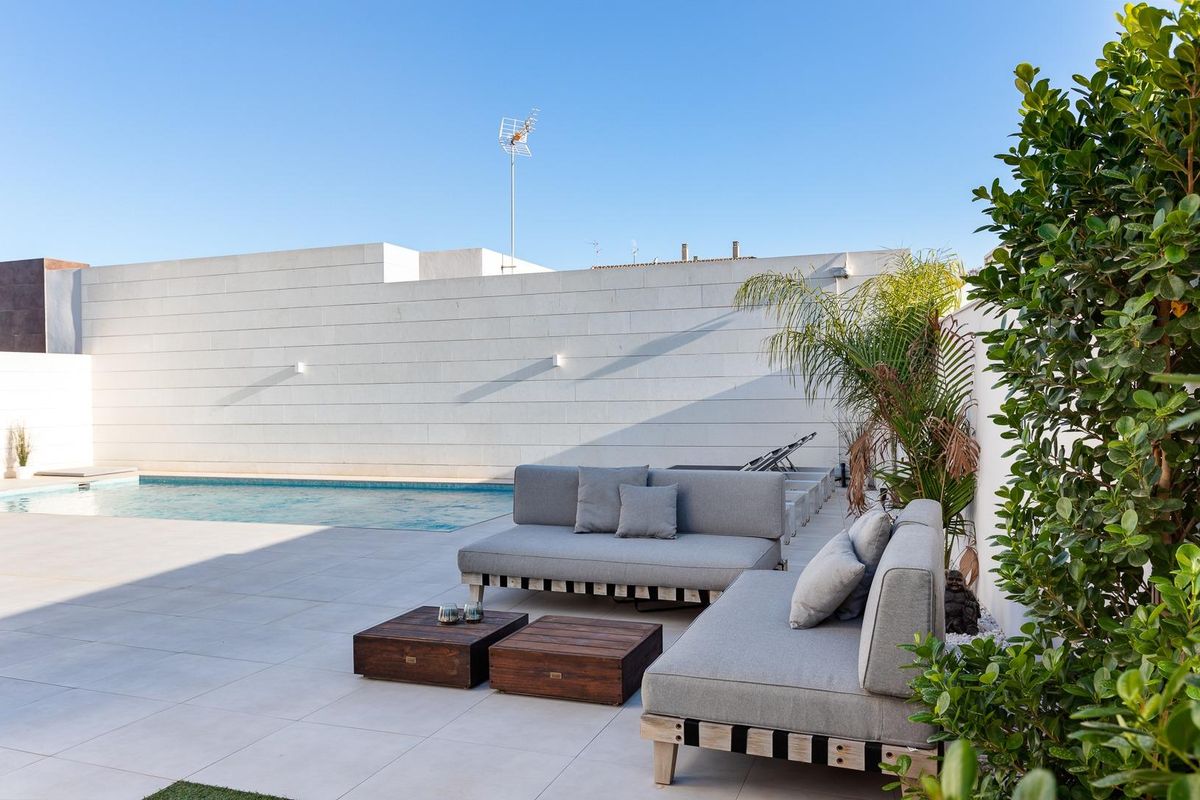Comfortabele loungezitplaatsen met zwembadzicht in het buitengebied van de villa in Pilar de La Horadada.