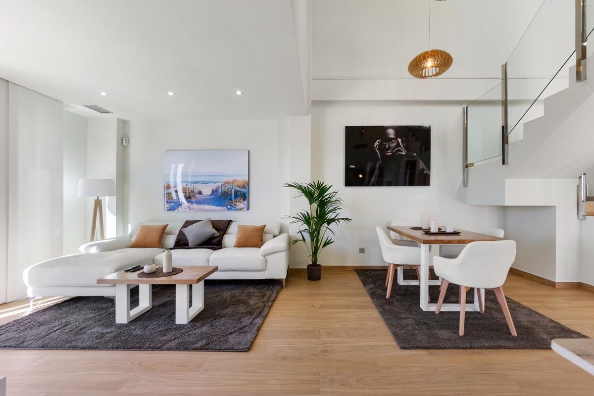 Stijlvolle woonkamer met natuurlijk licht, voorzien van een gezellige bank en eetruimte in villa Rojales.