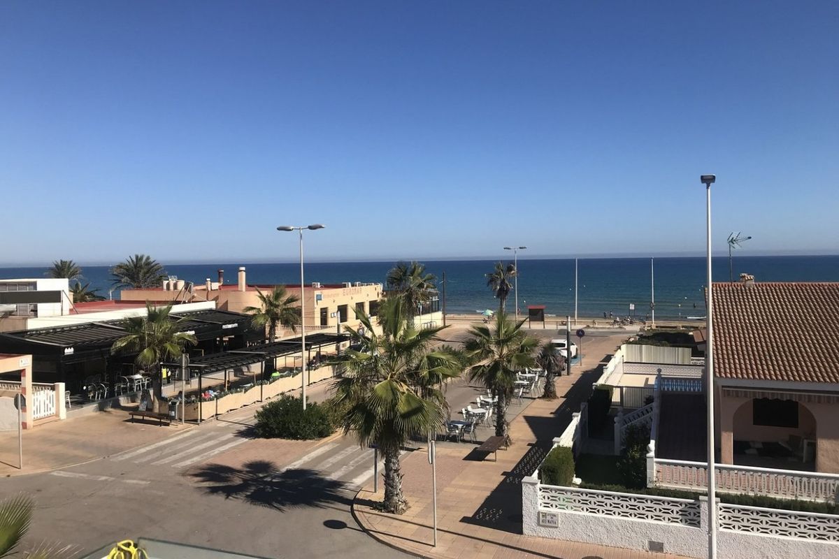 Schilderachtig uitzicht vanuit Torrevieja met strandrestaurants en palmbomen langs de kust.