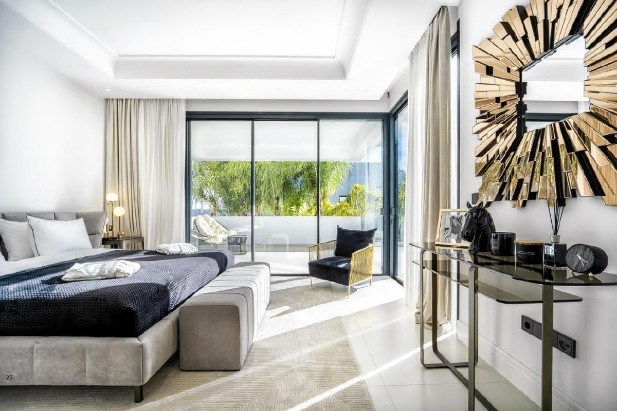 Chique slaapkamer met stijlvolle inrichting en directe toegang tot een ruim terras in villa aan de Costa del Sol.