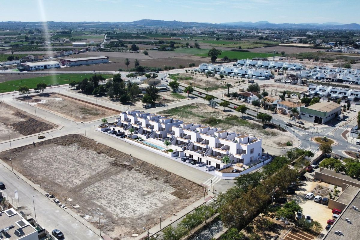 Brede luchtfoto van een nieuw woongebied in Dolores, Costa Blanca Zuid, met moderne appartementen en open ruimtes.