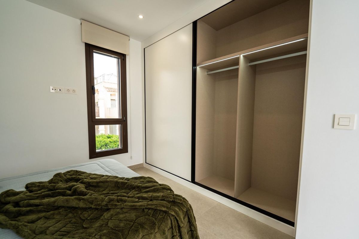 Ruim kleedgedeelte in een slaapkamer in een townhouse in Almoradi, met veel opbergruimte en een strak ontwerp.