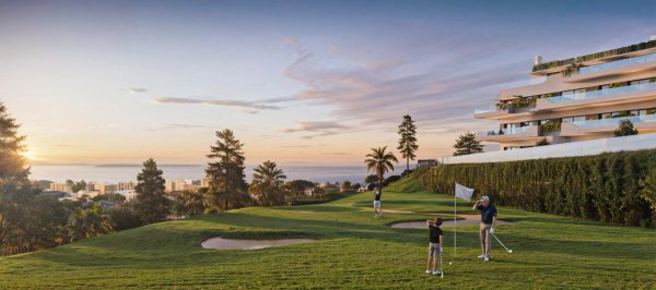 Uitzicht op golfers die genieten van het landschap in Mijas, Costa del Sol met de oceaan op de achtergrond.