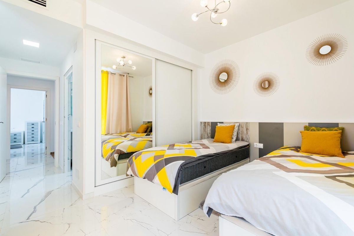 Inviting bedroom with two beds and stylish decor in the luxurious villa of Orihuela Costa.