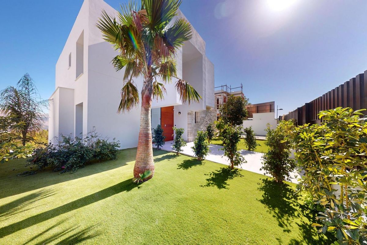 Levendig tuingebied van de villa in Polop, Costa Blanca, met weelderige planten en modern villa ontwerp.